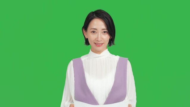 カメラ目線で話す女性　アナウンサー　クロマキー合成用グリーンバック