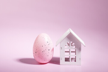 real estate purchase and sale,Easter egg and house on pink background, happy home decor, spring...