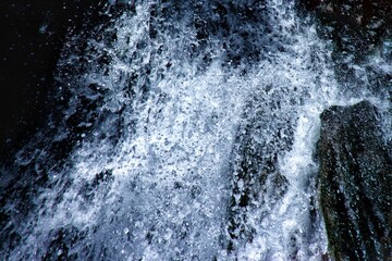 Detail of water splash of a waterfall in wild forest
