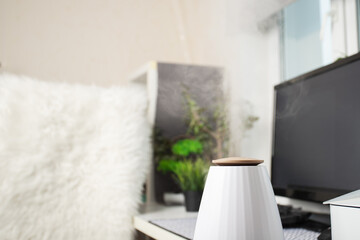 Air humidifier in the office, water vapor on the work table, modern workplace