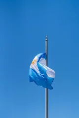 Tuinposter argentinian flag waving in the sky in buenos aires in argentina on sunny day © SandraSevJarocka