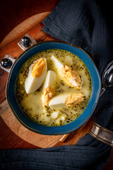 A bowl of soup sorrel with rice and boiled egg.