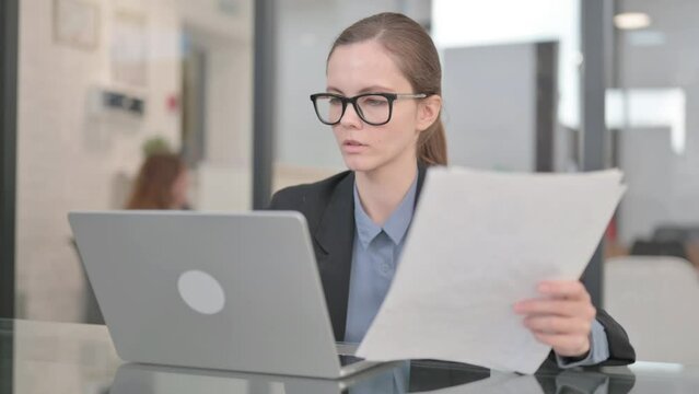 Businesswoman Doing Online Data Entry with Laptop and Docuemtns