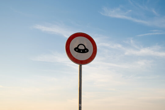 No entry for UFO traffic sign, isolated sunset sky.