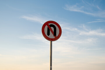 No U-turns traffic sign, isolated sunset sky.