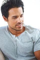 Obraz premium Face, smile and thinking with a young man in studio isolated on a white background for casual tshirt wear. Idea, future and vision with a happy young person looking thoughtful while contemplating