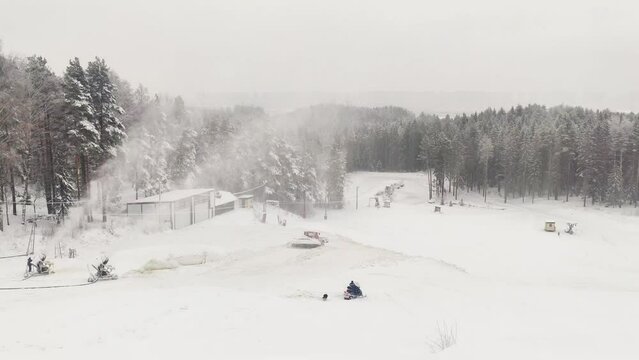 dog runs in the snow. Ski resort. a snowmobile moves along a snowy slope. 