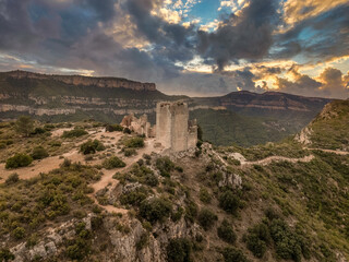 Fototapeta na wymiar Dramatic aerial sunset view of Chirel castle medieval ruin with square towers above the Jucar river in Spain
