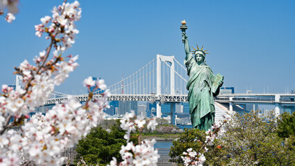 自由の女神像とレインボーブリッジ，満開の桜