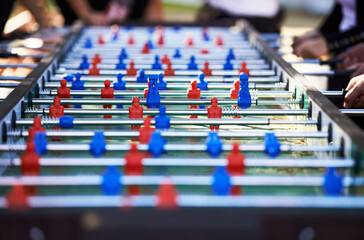 Foosball table, competitive and leisure with people playing a game outdoor at a music festival...