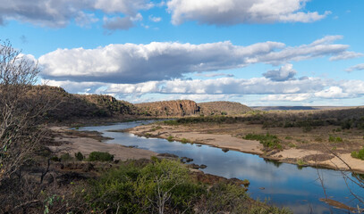 Obraz premium Olifants river, Kruger National Park, slowly winding its way toward a rocky outcrop of hills than rise up from the river bank. 