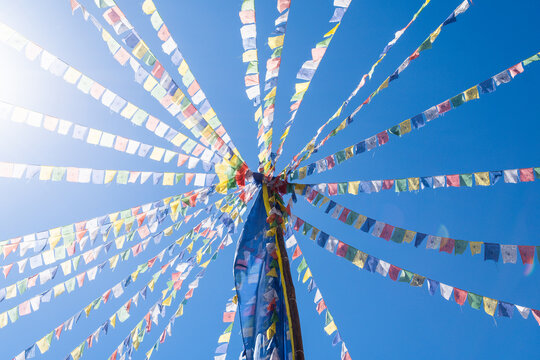 colorful prayer flags fluttering on a blue sky background