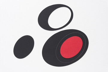 three graphic design elements (ovals) arranged on blank paper