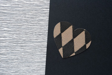 silver crepe paper and machine-cut decorative scrapbooking paper heart with diamantine patterns on black