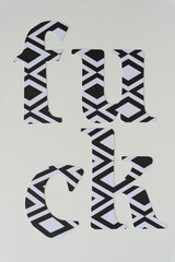 certain letters machine-cut using paper with black and white design on blank paper - obrazy, fototapety, plakaty