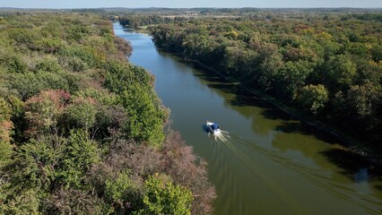 Boat traveling through green landscape with Seneca River in up state New York at Montezuma Wildlife...