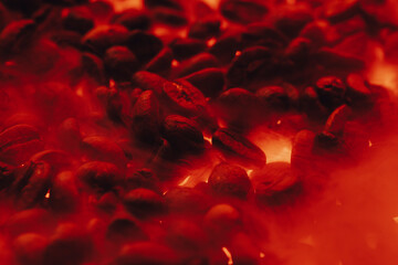 Roasted coffee beans with smoke and fire background. Close up,