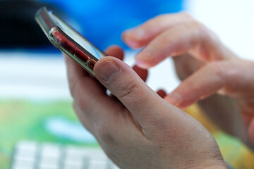 Close-up of middle aged woman writing text message with smartphone at home office at Swiss City of Zürich. Photo taken January 27th, 2024, Zurich, Switzerland.