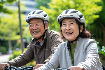senior asian couple riding bicycle together in the park. senior people lifestyle concept