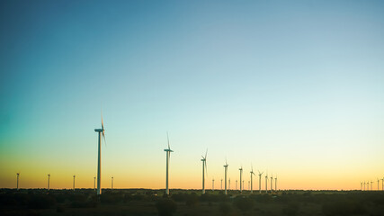 Obraz premium Wind turbines against a clear sky at dusk, symbolizing clean energy.