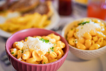 Creamy macaroni and cheese in a pink bowl, perfect for comfort food.