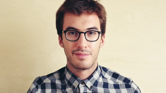 Face, nerd and man with glasses, frames and vision with stylish outfit on a studio background. Portrait, geek and model with eyewear, optometry and sight with a shirt, trendy clothes and mockup space