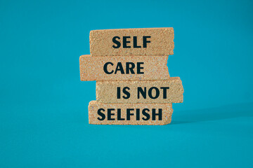 Naklejka premium Self care is not selfish symbol. Concept words Self care is not selfish on brick blocks. Beautiful blue background. Medical concept. Copy space.