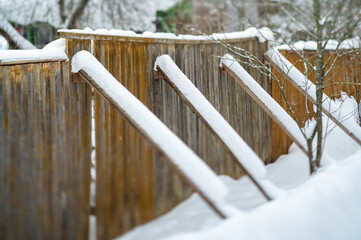 old wooden fence supported with sticks, winter scene