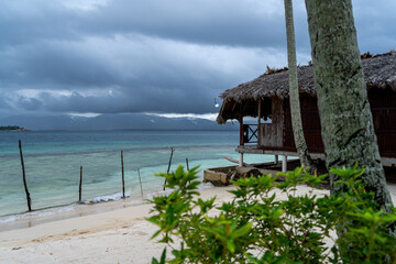 San Blas island hut with green plant in foreground and windy caribic sea