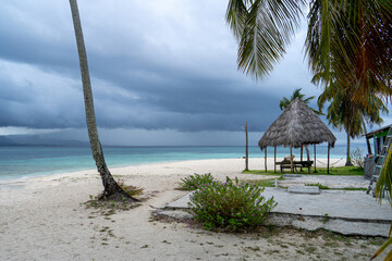 San Blas caribic island shelter hut on beautiful beach with single palm stem in windy weather