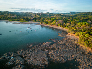 Aerial view of rocky coast line in Santa Catalina with boats and tropical forest in background © El Benedikt