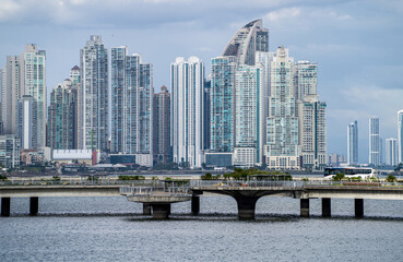 Dense Panama City skyline skyscrapers with bridge and water in foreground