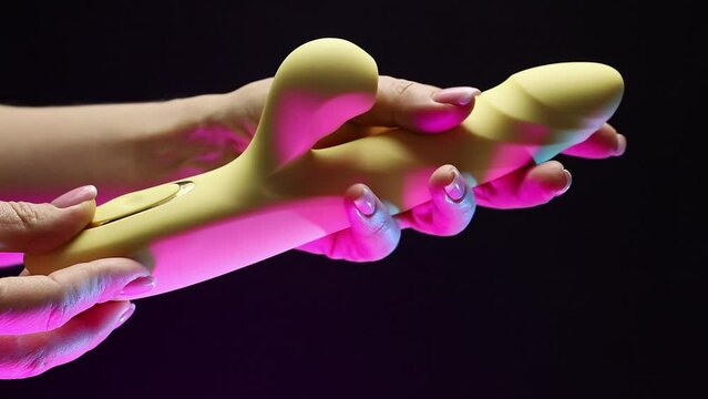 A woman's hand strokes an adult toy. The girl is holding a sex shop toy Sex toy clitoral vibrator