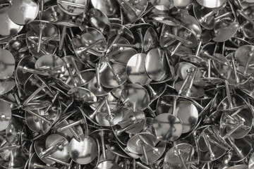 A pile of silver drawing pins. Office supplies