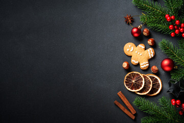 Gingerbread cookies, spices and Christmas decorations at black. Top view with space for text.