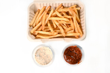French fries with mayonnaise and ketchup in biodegradable packaging fast food delivery