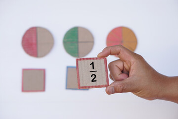 Hand hold paper card with fraction numbers. Circle paper show parts of color separation. Concept,...