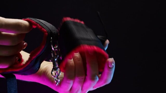In women's hands, soft handcuffs for erotic play. The girl is holding a sex shop toy Sex toy clitoral vibrator