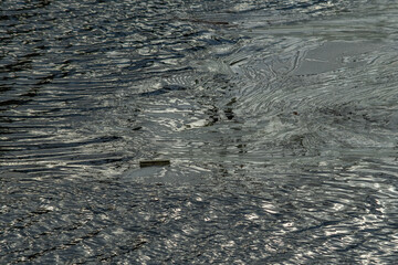 Melting of waste pollution on the water surface of a lake or river.
