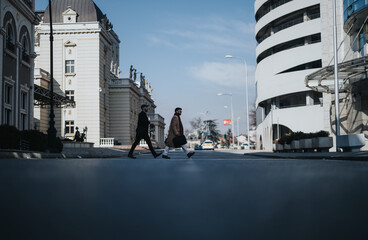 Fototapeta na wymiar Two stylish friends walking confidently in an urban setting on a sunny day.