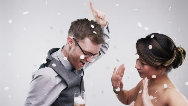Couple, dancing or celebration in studio with champagne, care or wedding party or confetti by white background. Man, woman and cool on dance floor in crazy energy, happy and bonding together for love