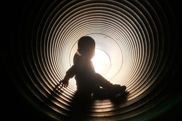 Child playing in corrugated pipe