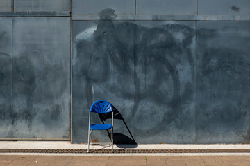 Blue Chair in-front of a metal wall