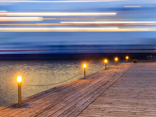 Long Exposure of a Moving Ship Overlooking a Pier at Twilight