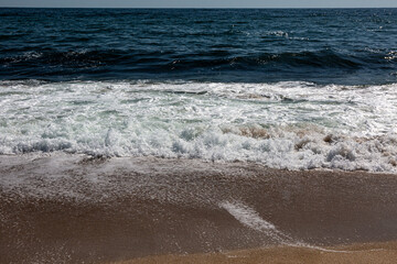 Fototapeta na wymiar Sandy beach, waves and sea