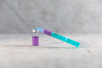 Spritze mit Nadel und einer Durchstechflasche aus Glas für Medizin