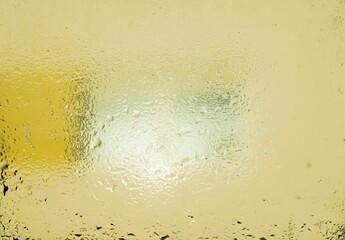 Abstraktes Motiv mit Wassermuster auf beschlagener Glasscheibe vor beiger Hausfassade mit fenstern...