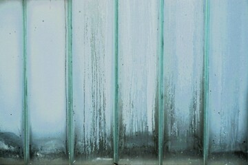 Grau-blaue Glaswand mit Wassermuster 