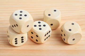 Dice cubes on wooden table, copy space.