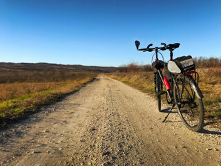 Fototapeta na wymiar Photo of black color touring bicycle parked at country side road on sunny winter day